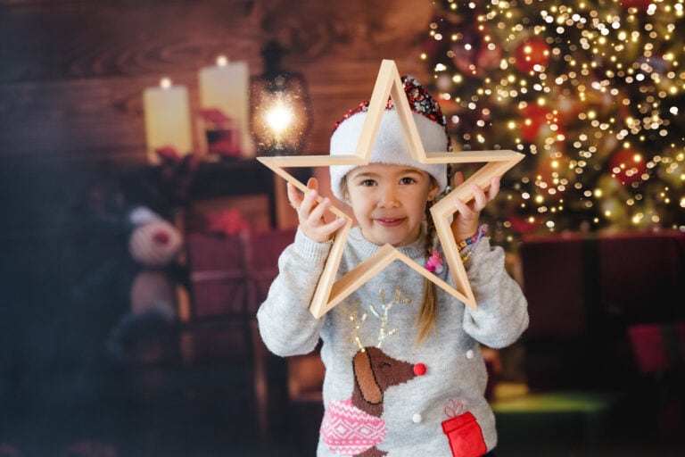 Leuchtender Weihnachtsbaum mit bunten Lichtern und Geschenken, festliche Dekoration, Kinderfeststimmung.
