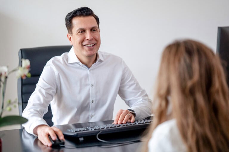 freundlicher mann im büro im gespräch mit kundin, business meeting, professionelles gespräch, arbeitsplatz mit computer, freundlicher ausschnitt