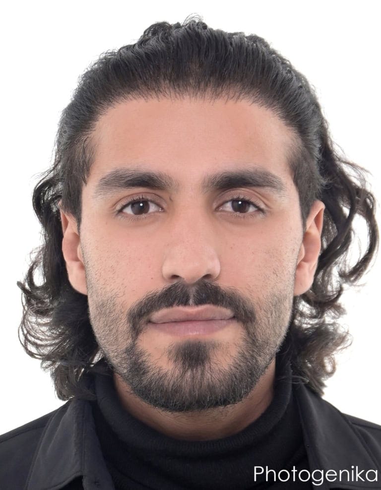 Biometrisches Passbild eines jungen Mannes mit Bart und dunkler Kleidung.